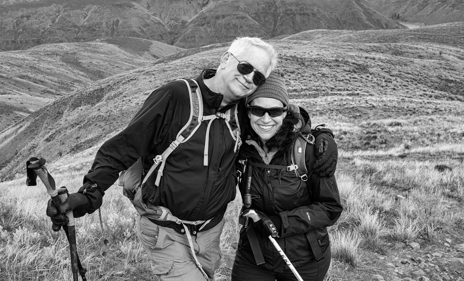 A smiling couple in their fifties on a hiking trail